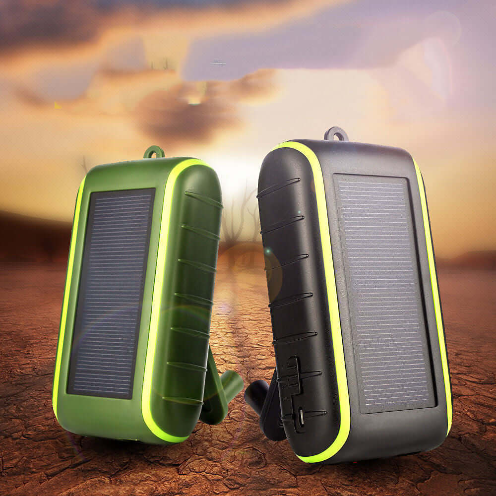 The solar power bank charger in green and black outdoors in a desert environment.