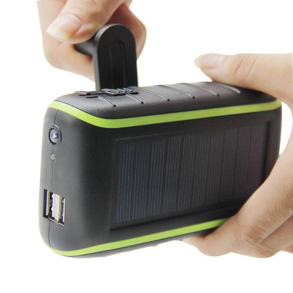 The solar power bank charger and its handle being held by someone.