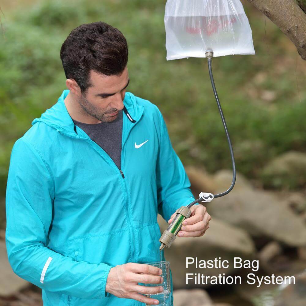 A man outdoors using the water purification straw and the bag filtration system.